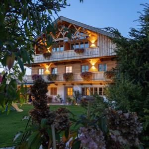 a large house with lights on the front of it at Ferienwohnung Schmickhof in Gaißach