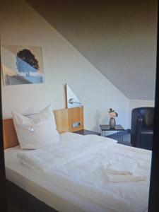 a bed with white sheets and pillows in a room at Hotel Götz in Groß Kreutz