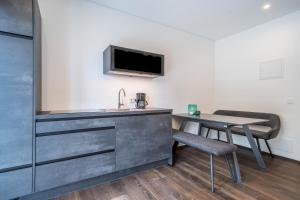 a room with a kitchen and a table and a tv at Naturapartments Alpreid Tanne in San Pancrazio dʼUltimo +9 photos