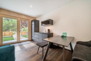 a living room with a table and a kitchen at Naturapartments Alpreid Tanne in San Pancrazio dʼUltimo