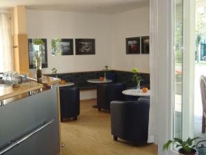 a restaurant with two tables and chairs with plants on them at Hotel Götz in Groß Kreutz