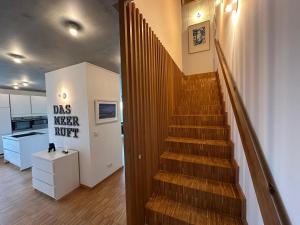 a stairway in a room with a kitchen and a stair at Großzügiges modernes Ferienhaus in Neuharlingersiel +31 photos