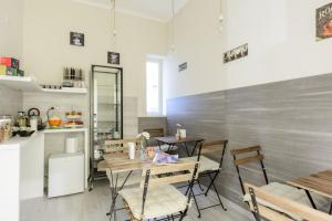 a dining room with tables and chairs and a kitchen at Morra's Home in Naples