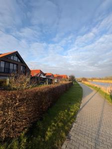 a path next to a house next to a body of water at Großzügiges modernes Ferienhaus in Neuharlingersiel