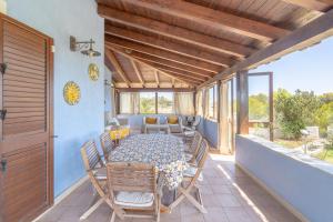 a dining room with a table and chairs on a balcony at La Casa del Vento Plemmirio in Plemmirio