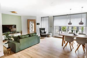a living room with a green couch and a table at Fewo Waldfeeling in Brilon