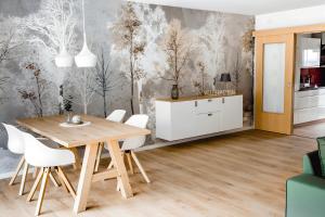 a dining room with a wooden table and white chairs at Fewo Waldfeeling in Brilon +23 photos