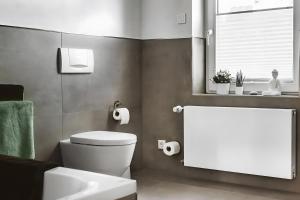 a bathroom with a toilet and a sink and a window at Fewo Waldfeeling in Brilon