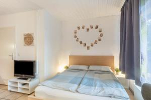 a bedroom with a bed and a heart decoration on the wall at 1 Zimmer Ferienwohnung in Lohfelden