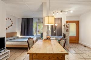 a living room with a wooden table and a bed at 1 Zimmer Ferienwohnung in Lohfelden