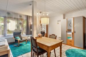 a living room with a wooden table and chairs at 1 Zimmer Ferienwohnung in Lohfelden +11 photos