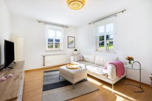 a living room with a white couch and a tv at Fewo Allezeit Sauerland in Drolshagen
