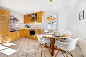 a kitchen with a wooden table and white chairs at Fewo Allezeit Sauerland in Drolshagen