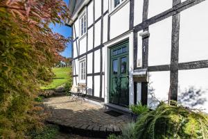 a white and green building with a green door at Fewo Allezeit Sauerland in Drolshagen