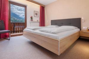 a bedroom with a large bed and a large window at Ferienwohnung Haus Christine in Rifiano +35 photos