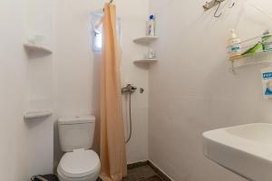 a bathroom with a toilet and a sink at Charmante ferienwohnung in Tinos +13 photos