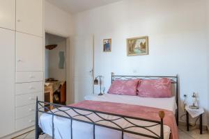 a bedroom with a bed with pink pillows at Charmante ferienwohnung in Tinos