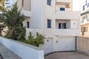 a white building with a white gate and a white fence at Charmante ferienwohnung in Tinos