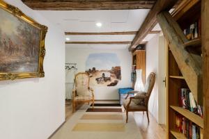 a hallway with two chairs and a painting on the wall at Bachbubenhof in Hüfingen