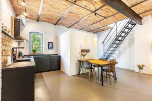 a kitchen and dining room with a wooden table and chairs at Ferienwohnung im Pferdestall in Angermünde +23 photos
