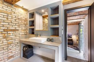 a bathroom with a sink and a brick wall at Ferienwohnung im Pferdestall in Angermünde