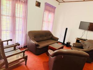 a living room with two chairs and a tv at C&C Holiday Home in Nikawatawana
