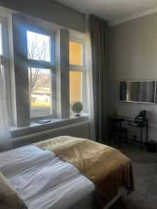 a bedroom with a bed and a window at Orsa Järnvägshotell in Orsa