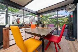 a dining room with a table and colorful chairs at Mobilhome - Piscine - Premium in Erdeven