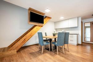 a dining room with a table and a tv on the wall at App Kronplatz Villa Colli in Valdaora