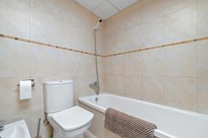 a bathroom with a toilet and a bath tub at Sara in L'Aldea +12 photos