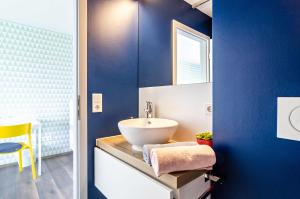 a bathroom with a sink and a blue wall at Kleine Auszeit in Thalheim +18 photos
