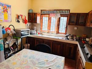 a kitchen with a table and a counter top at C&C Holiday Home in Nikawatawana +3 photos