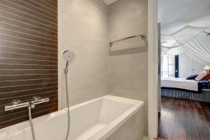 a bathroom with a bath tub and a bed at Apartment - Car included in Estepona +20 photos