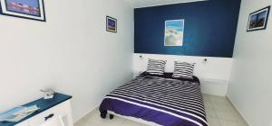 a bedroom with a bed with two striped pillows at Maison du centre - ruelle calme in La Tranche-sur-Mer