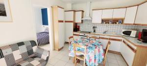 a kitchen with a table and chairs in a room at Maison du centre - ruelle calme in La Tranche-sur-Mer +5 photos