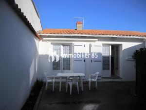 a table and chairs in front of a white building at Maison du centre - ruelle calme in La Tranche-sur-Mer