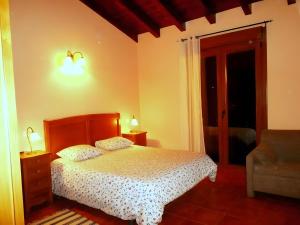 a bedroom with a bed and a chair at Los Cerezos in Rada