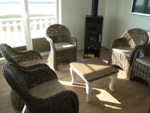 a living room with wicker chairs and a coffee table at Strand Hus by Seeblick Ferien in Olpenitz