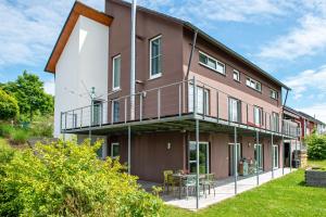 an apartment building with a balcony and a table at Kleine Auszeit in Thalheim