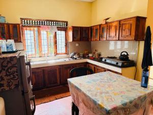 a kitchen with wooden cabinets and a table in it at C&C Holiday Home in Nikawatawana