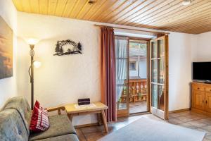 a living room with a couch and a television at Haus Verena Mittenwald in Mittenwald