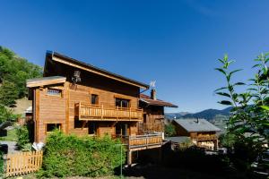 a log house with a deck and a mountain at Meribel le chalet d'eugénie in Les Allues