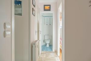 a white bathroom with a toilet in a hallway at Appartement Le Rial - Erquy in Erquy +14 photos