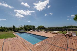 a swimming pool on a wooden deck with lounge chairs at Chambre d'hôtes - Ty Castel in Ploeren