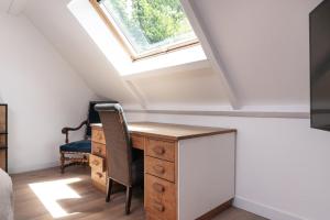 a attic bedroom with a desk and a window at Chambre d'hôtes - Ty Castel in Ploeren