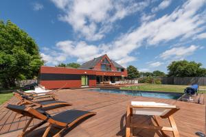 a deck with lounge chairs and a swimming pool at Chambre d'hôtes - Ty Castel in Ploeren