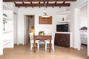 a dining room with a table and a television at Villa Kassiopea in Cala Blanca