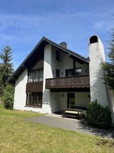 a white building with a bench in front of it at Haus Azalea in Olsberg