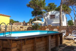 a pool in a yard with a house in the background at Villa Kassiopea in Cala Blanca