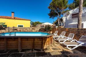 a group of chairs sitting around a swimming pool at Villa Kassiopea in Cala Blanca